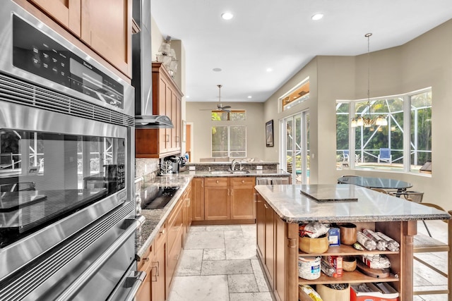 kitchen featuring pendant lighting, a breakfast bar, black electric cooktop, and double oven