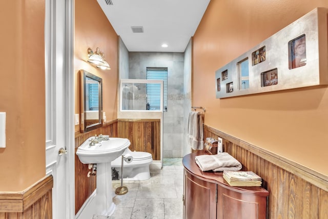 bathroom featuring wooden walls and toilet