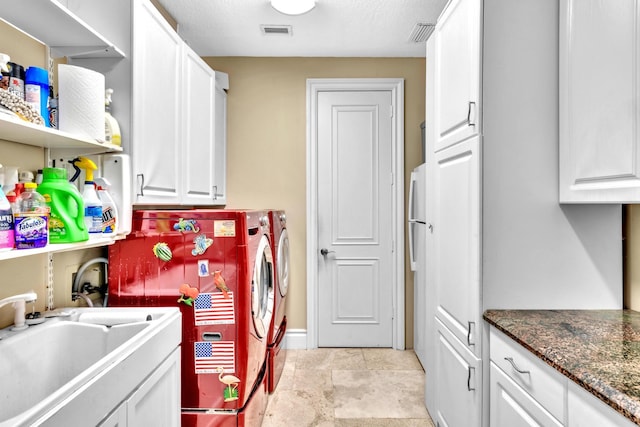 washroom featuring washer and clothes dryer, sink, cabinets, and a textured ceiling