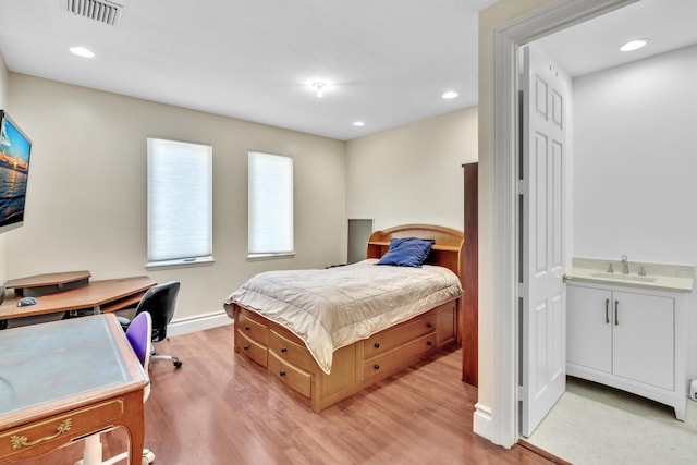 bedroom featuring sink and light wood-type flooring