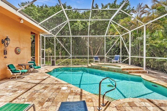 view of swimming pool with glass enclosure, an in ground hot tub, and a patio