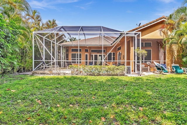 back of house featuring a lawn and glass enclosure