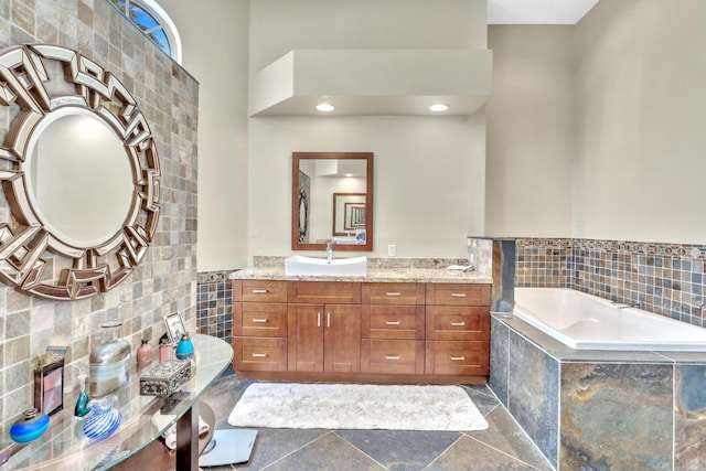 bathroom featuring vanity and tiled bath