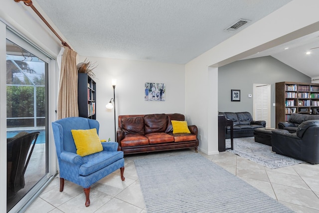 tiled living room featuring lofted ceiling and a textured ceiling