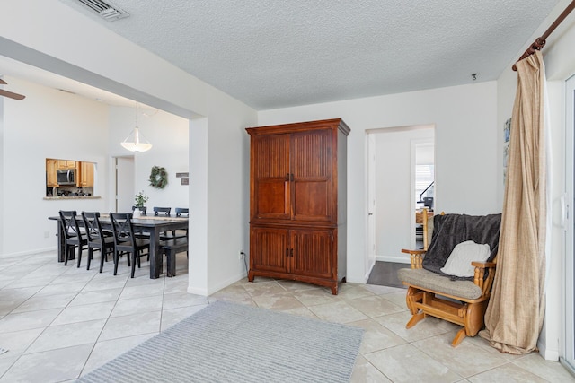 interior space featuring a textured ceiling and light tile patterned flooring