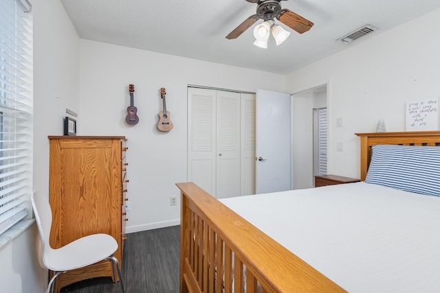 bedroom with a textured ceiling, a closet, dark hardwood / wood-style floors, and ceiling fan