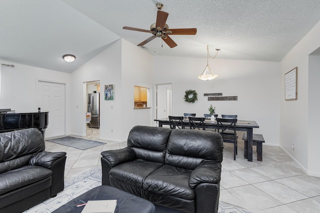 tiled living room with a textured ceiling, high vaulted ceiling, and ceiling fan