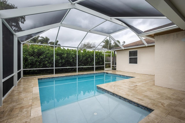 view of pool with glass enclosure and a patio area