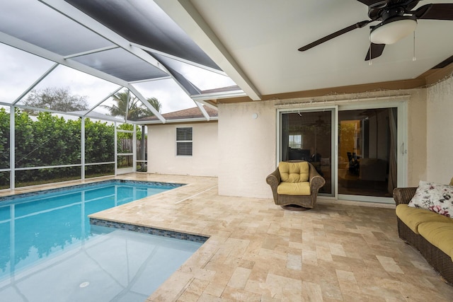 view of swimming pool with a patio area, ceiling fan, and glass enclosure