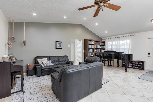 living room with a textured ceiling, vaulted ceiling, ceiling fan, and light tile patterned flooring