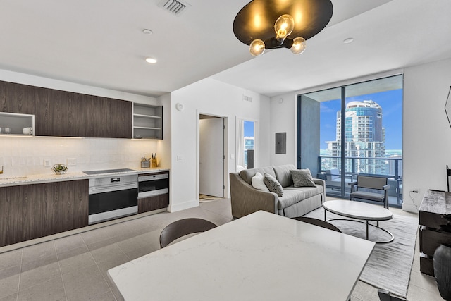 601 NE 1st Ave Unit 4813, Miami, FL 33132 - kitchen featuring stainless steel oven, open shelves, dark brown cabinets, expansive windows, and black electric cooktop