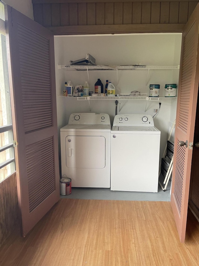 clothes washing area with light hardwood / wood-style floors and independent washer and dryer