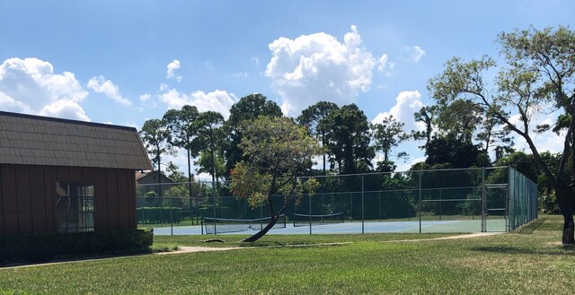 view of sport court featuring a lawn