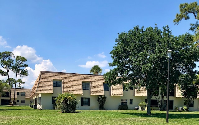 view of front facade featuring a front yard and central AC