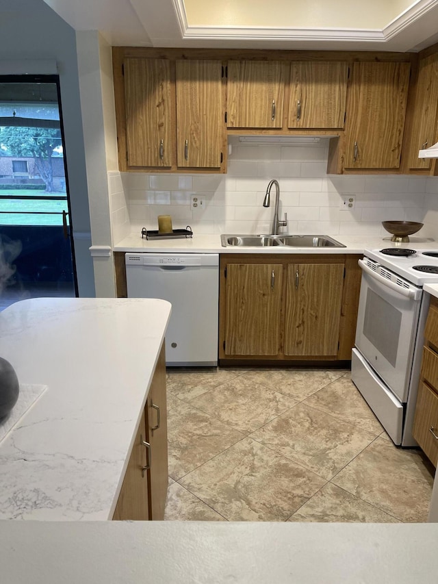 kitchen featuring white appliances, tasteful backsplash, and sink