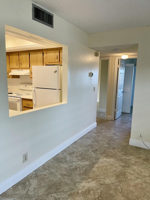 kitchen with white appliances and a textured ceiling