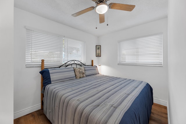 bedroom featuring ceiling fan, dark wood-type flooring, and a textured ceiling