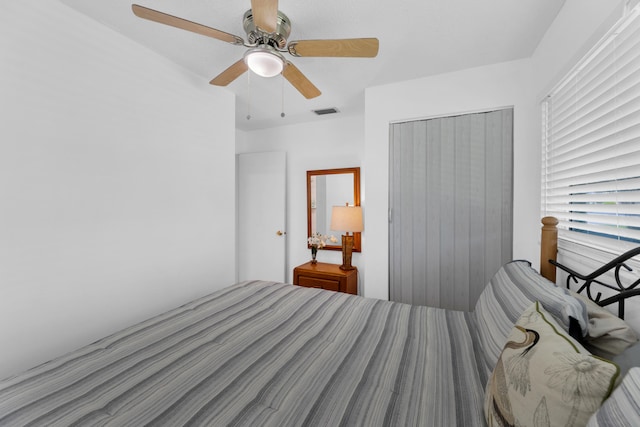 bedroom with ceiling fan and a closet