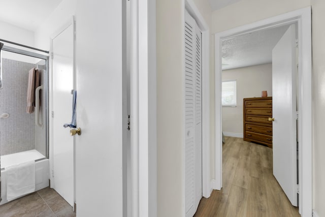 hallway featuring a textured ceiling and light hardwood / wood-style flooring