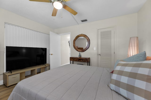 bedroom with ceiling fan, a closet, and light hardwood / wood-style floors