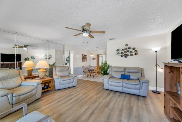 living room with light wood-type flooring, a textured ceiling, and ceiling fan