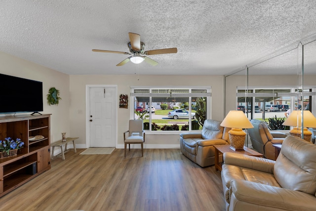 living room featuring ceiling fan, a textured ceiling, and hardwood / wood-style floors