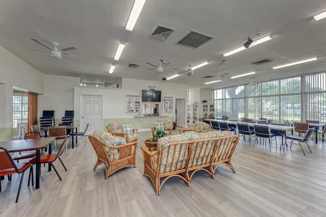 living room with light wood-type flooring, a healthy amount of sunlight, and ceiling fan