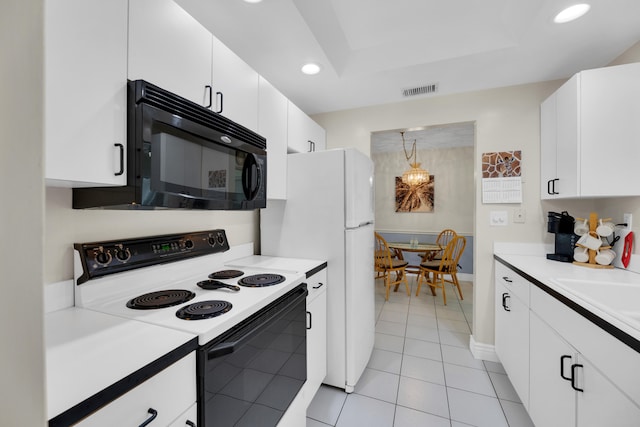 kitchen with light tile patterned floors, sink, electric range, and white cabinets