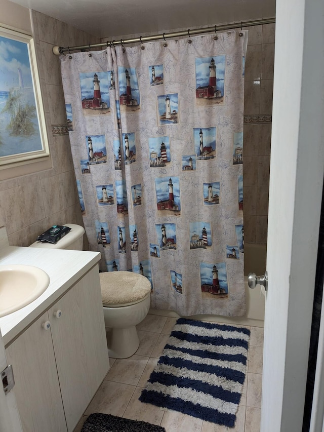 full bathroom with tile walls, tile patterned flooring, shower / bathtub combination with curtain, vanity, and toilet