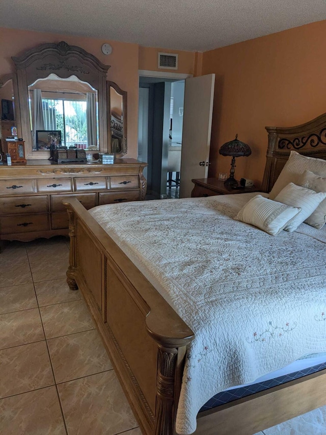 bedroom featuring a textured ceiling and light tile patterned floors