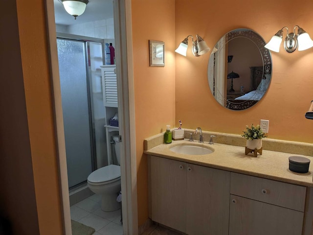 bathroom featuring tile patterned flooring, walk in shower, vanity, and toilet