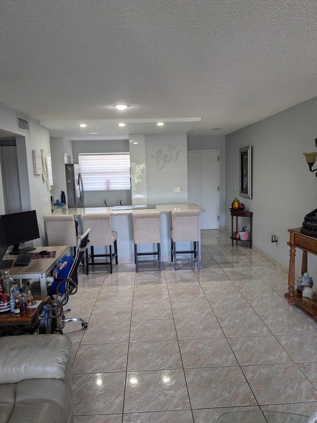 tiled living room with a textured ceiling