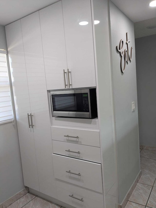 details featuring white cabinets and light tile patterned floors