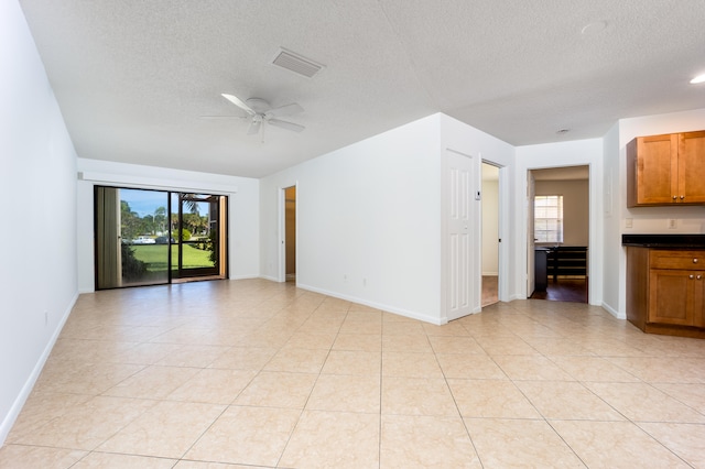 interior space with a textured ceiling, plenty of natural light, and ceiling fan