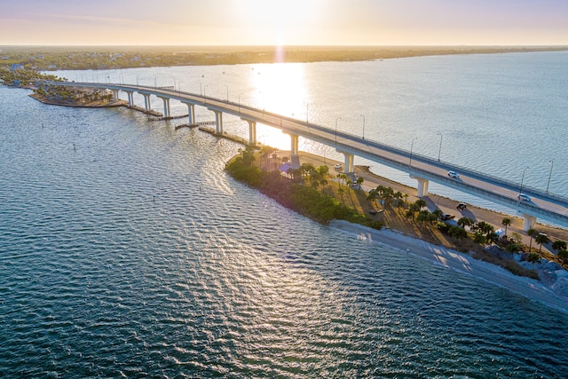 aerial view at dusk featuring a water view