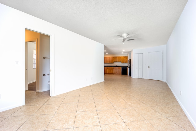 tiled spare room featuring a textured ceiling and ceiling fan