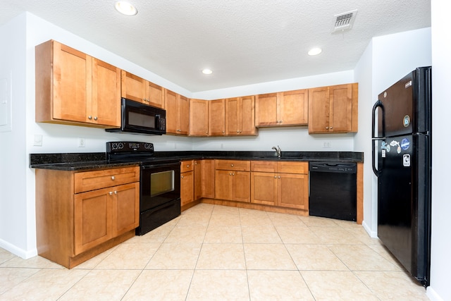 kitchen featuring black appliances, light tile patterned floors, and sink