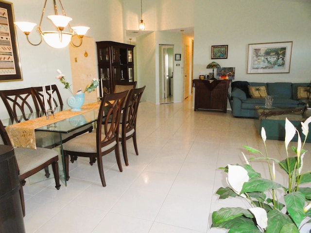 dining space with a high ceiling, tile patterned flooring, and a notable chandelier