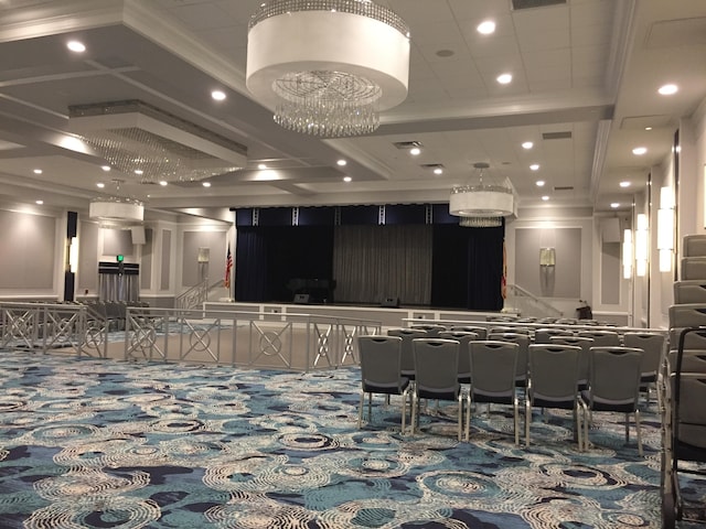 interior space with carpet floors, a notable chandelier, and crown molding