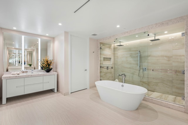 bathroom featuring shower with separate bathtub and vanity