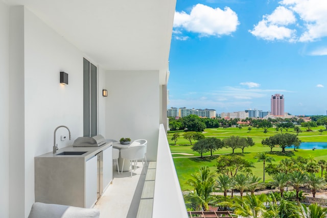 balcony with an outdoor kitchen and sink