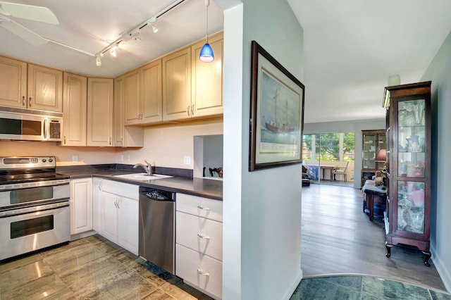 kitchen featuring light hardwood / wood-style floors, sink, hanging light fixtures, appliances with stainless steel finishes, and ceiling fan