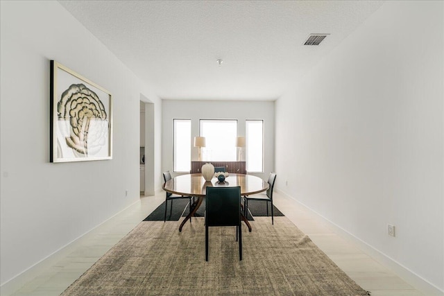 dining space featuring a textured ceiling