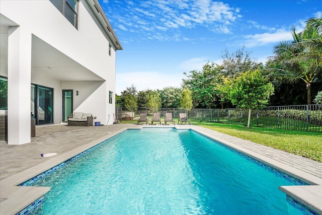 view of pool with a patio area and a lawn