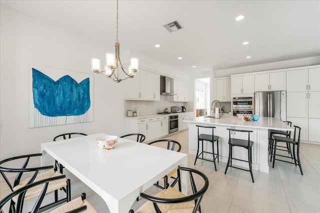 tiled dining room with sink and a chandelier