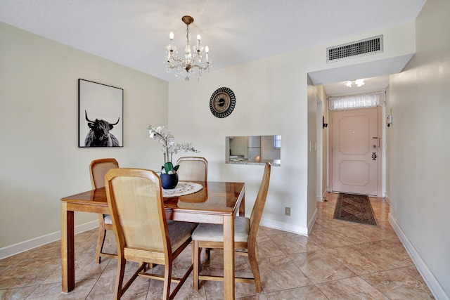 dining area featuring a chandelier and a textured ceiling