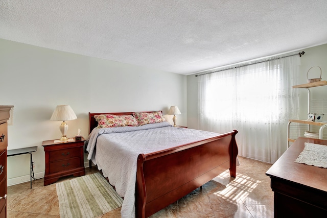 bedroom featuring a textured ceiling and light tile patterned flooring