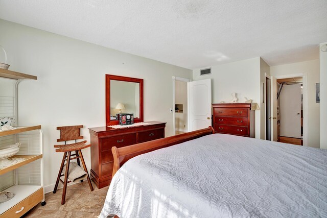 bedroom with a textured ceiling and a closet