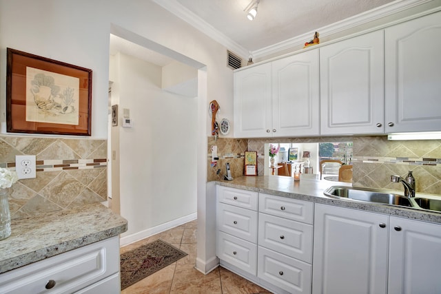 kitchen with a textured ceiling, sink, white cabinets, light tile patterned floors, and ornamental molding