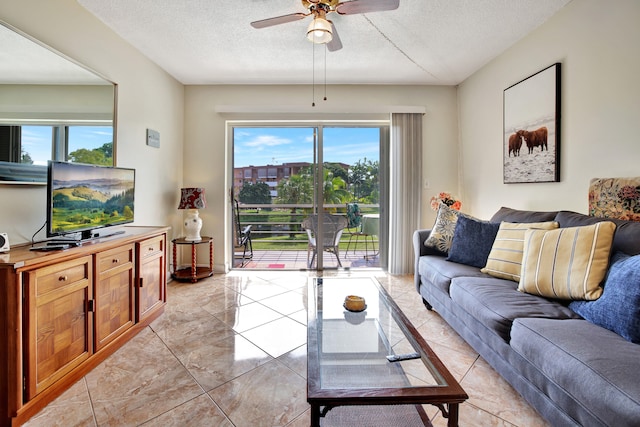 living room featuring a textured ceiling, ceiling fan, and a wealth of natural light